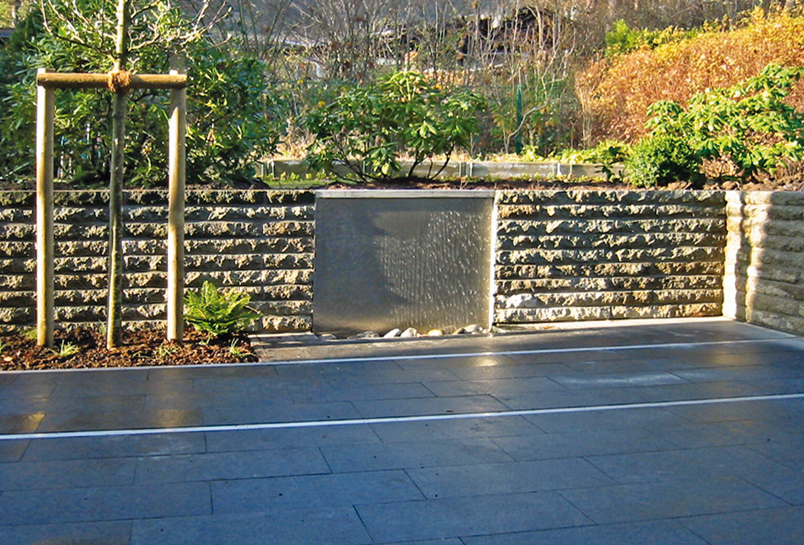 Edelstahlbrunnen in Werksteinmauer